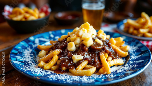 A classic Canadian poutine piles crispy golden fries with springy cheese curds and rich brown gravy on a blue plate, a hearty comfort food favorite served fresh and piping hot.