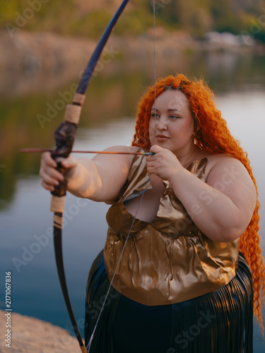 Bild auf Leinwand Close-up Plus Size Redhead Archer Woman Aiming Bow Outdoor