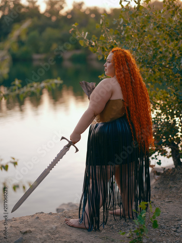 Quadro su tela Plus Size Redhead Warrior Woman Standing With Sword By Lake