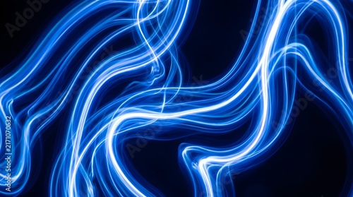 Abstract blue light trails creating dynamic wavy lines on dark background.