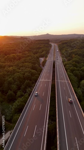 Aerial drone descending under a highway viaduct at sunset in Allariz