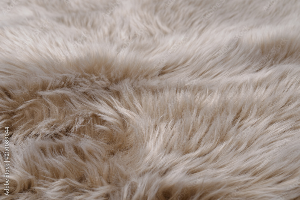 Obraz premium Perspective close-up of soft beige faux fur carpet texture for interior background