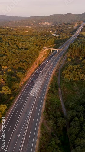 Aerial drone view flying over highway traffic at sunset