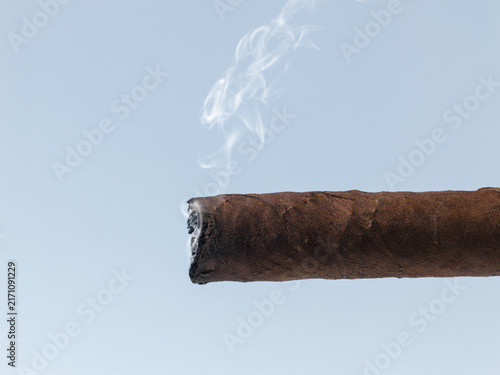 Fotografie Lit Cuban Cigar with Wispy Smoke Close Up