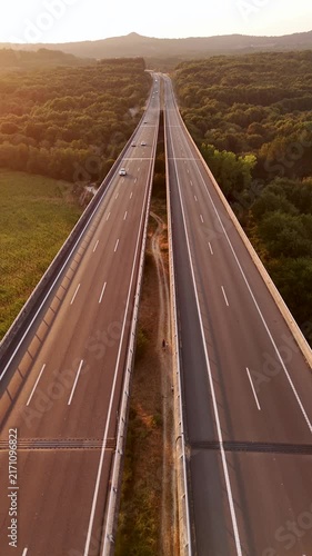 Cars driving on a highway viaduct at sunset