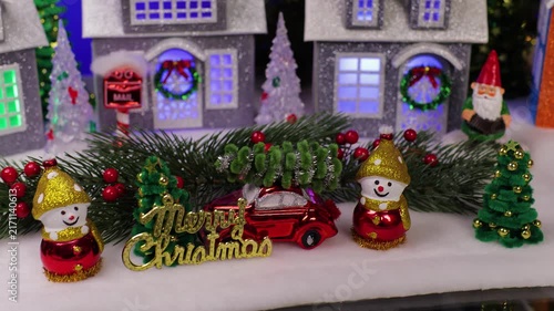 An orange car pulls up in front of a beautiful Christmas town