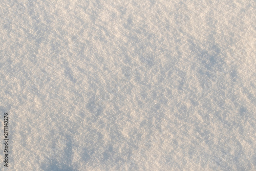 Sparkling snow texture with shadows close-up in winter