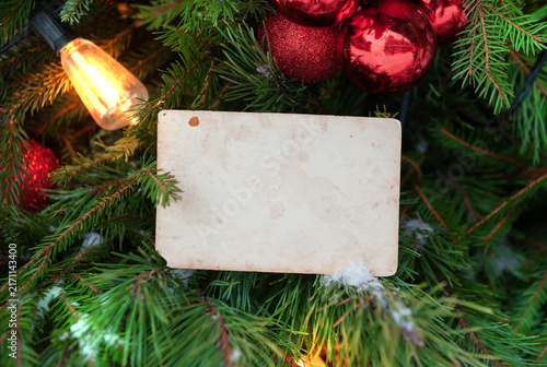 Christmas tree with blank vintage card and red ornaments