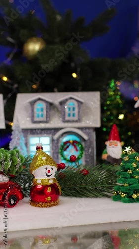 A funny Santa Claus jumps against the backdrop of a Christmas town