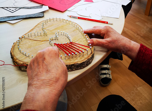 Foto Close-up detail of an elderly woman’s hands shaping a heart from cotton by hand