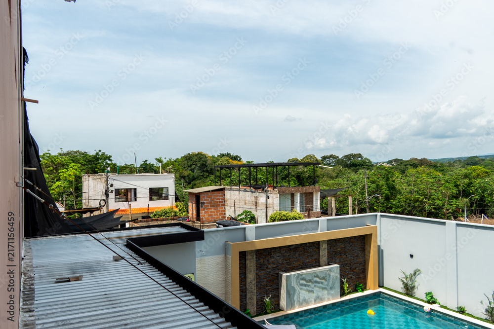 Naklejka premium Modern rooftop view with swimming pool and surrounding greenery