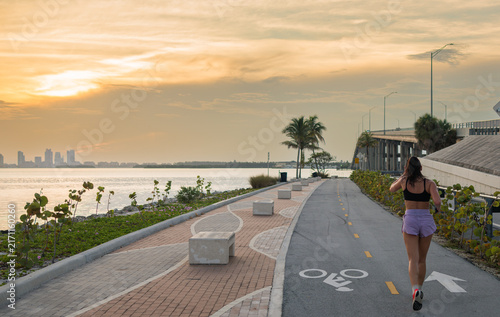Woman Jogging on Waterfront Bike Path at Sunset in Miami