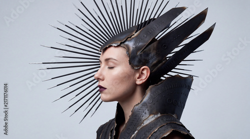 Elegant side profile of a futuristic woman wearing an artistic black feather and spike headdress, combining fashion, fantasy, beauty, and avant-garde visual design.