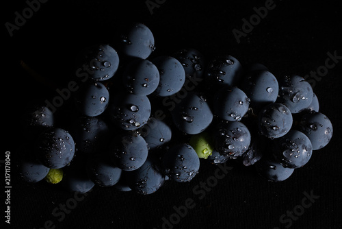 Konstfotografi Bunch of black grapes with water droplets isolated on black studio background, l