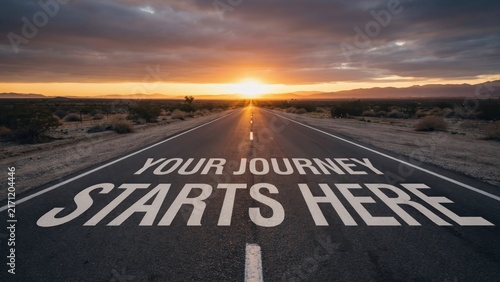 Text Your Journey Starts Here painted on a desert road at sunrise. This represents new beginnings and business opportunity concepts.