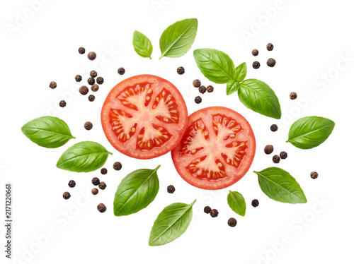 Fresh tomato slices with green basil leaves and black peppercorns, organic vegetable salad ingredients on white background, raw food flat lay
