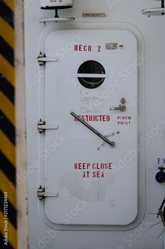 Weather-tight access door on Deck 2 of an offshore support vessel, marked “RESTRICTED” and “KEEP CLOSED AT SEA.” The door provides controlled access between vessel spaces