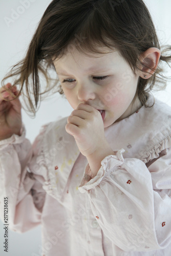 Bild auf Leinwand A closeup of a sad little girl tries to comfort herself by sucking her thumb while feeling upset, sick or emotionally down at home