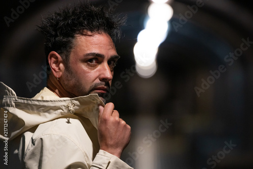 Fotografie Portrait of a stylish man with spiky dark hair and beard glancing over his shoul