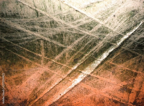 Weathered grunge abstract texture with scratched metal surfaces and warm tones