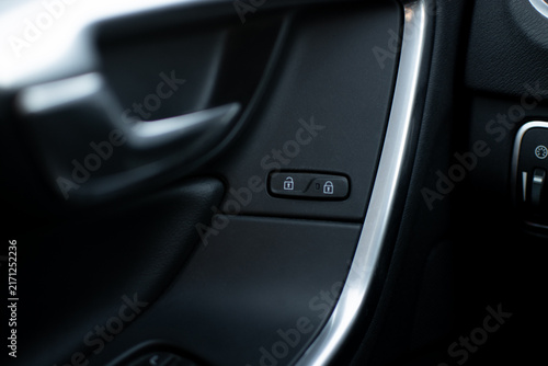 Close-up of a Volvo car door panel with central locking controls, lock and unlock icons
