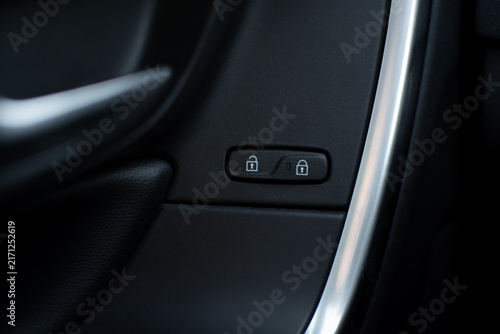 Close-up of a Volvo car door panel with central locking controls, lock and unlock icons