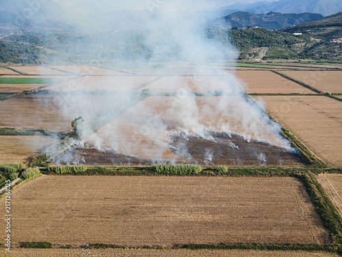 Konstfotografi Large crop residue fire producing dense smoke over flat farmland
