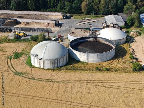 Rural biogas facility with large circular digesters from above, overhead view