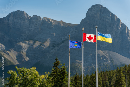 Provincial flag of Alberta, Canadian flag, and Ukrainian flag flying together in the Rockies. Canmore, Alberta, Canada.