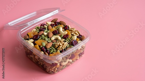 A clear plastic container filled with a healthy mix of assorted nuts and dried fruits