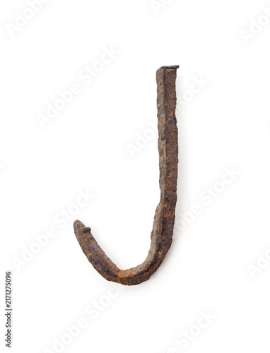 Letter J made from old bent rusty nail isolated on white background.