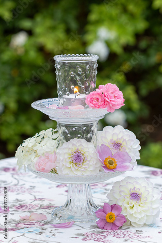 weiße Dahlien, pink Rosen, Herbstanemonen und Windlicht auf einer Glasetagere als romantische Dekoration