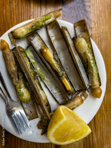 Razor clams on plate with lemon wedge