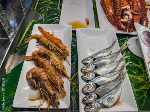 Fresh seafood display offering shrimp, fish, and octopus