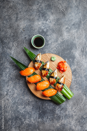 Sashimi sushi set on wooden board. Stone background. Top view