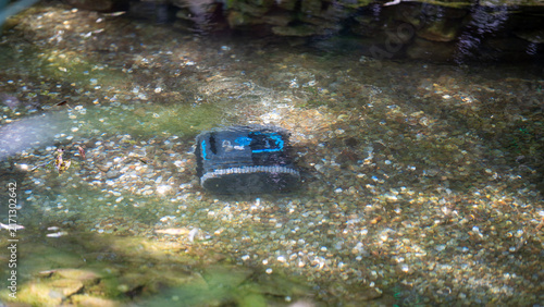фотографія Water pollution caused by a discarded plastic item in a stream during daylight
