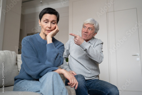 Canvas Print Hysterical egoistic elderly husband accusing and provoking upset older wife duri