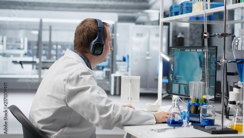 Konstfotografi Unconventional scientist listens to music through headphones while conducting a lab experiment in molecular biology and biotechnology research