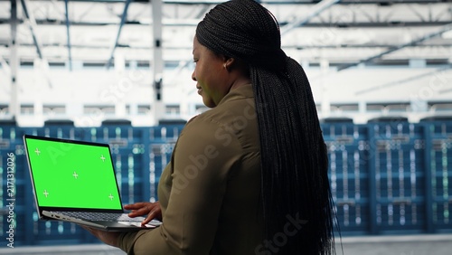 Fotografie Data center technician uses an isolated-screen laptop to deploy new server architecture and a cybersecurity framework while protecting data