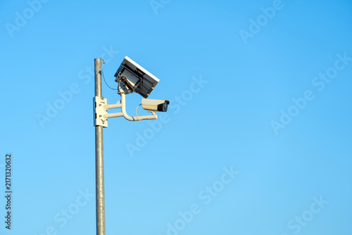 Canvastavla Security camera mounted on a pole, powered by a solar panel, monitoring an area