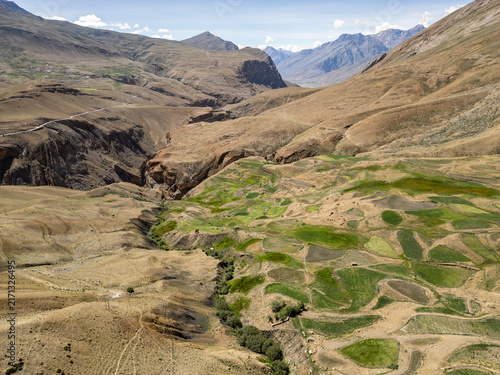 Aerial view of terraced fields and a deep valley landscape near the village of Chicham in the arid Himalayan mountains in Chicham, Himachal Pradesh, India.