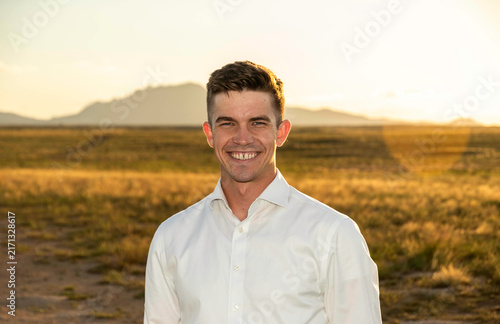 Smiling man in white shirt at golden hour desert