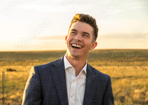Fotografie Smiling man in suit outdoors at golden hour