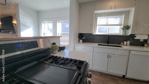 Bright modern kitchen with white cabinets and stainless range