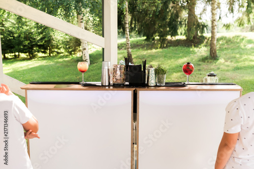 Bild auf Leinwand Modern Outdoor Cocktail Bar Setup with Colorful Drinks, Bar Tools and Glassware