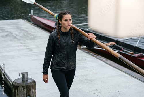Sculling athlete walking on dock with oar and copy space for sports campaign