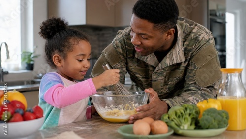 Soldier and Young Girl Mixing Batter in Home Kitchen