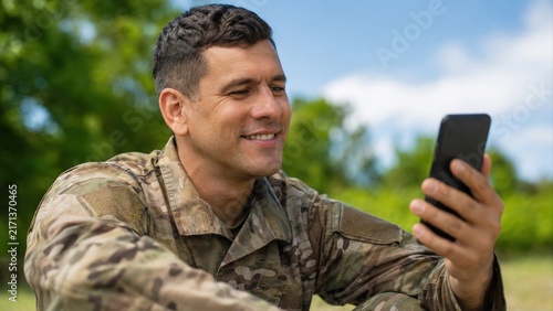 Smiling Soldier Using Smartphone Outdoors on Break