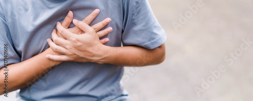 Foto Unrecognizable man clutching his chest in pain outdoors with copy space