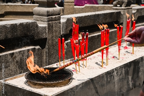 Obraz na plátně Burning red ritual joss stick incense candles with smoke and flame inside histor